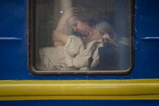 Женщина у окна в поезде, следующем во Львов. Киев, 3 марта 2022 года