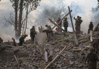 Спасатели и военные работают на месте разрушенной школы в Краматорске