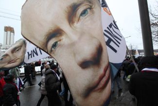 В шествии в поддержку Путина 23 февраля приняли участие десятки тысяч людей. Они прошли по Фрунзенской набережной до стадиона «Лужники», где им предстояло услышать предвыборную речь своего кандидата в президенты