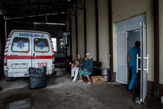 Пациентки отдыхают возле входа в госпиталь