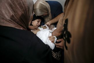 Женщина оплакивает свою погибшую дочь в госпитале Газы, 9 октября 2023 года. ЦАХАЛ заявил, что в ночь на 9 октября нанес удары по 500 целям в секторе Газа в ответ на нападение боевиков ХАМАС. Палестинские власти сообщали, что на тот момент в ходе обстрелов погибли более 500 жителей Газы, в том числе 91 ребенок.