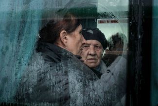 Украинские женщины ждут автобуса для эвакуации из Купянска. В городе, который более полугода находился под контролем ВС РФ, сейчас идут бои