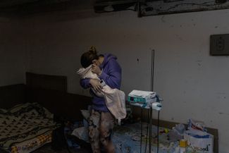 Мать с ребенком в подвале детской больницы, который используется как бомбоубежище. Киев, 28 февраля 2022 года
