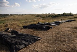 Мешки с телами погибших солдат на поле вблизи линии фронта в районе Бахмута, Донецкая область, 1 августа 2024 года