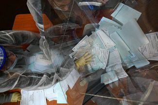 Члены участковой избирательной комиссии опустошают урну для голосования по поправкам в Конституцию. Владивосток, 1 июля 2020 года