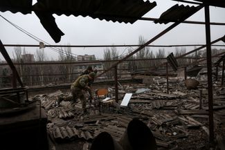 Украинские военные снимают оборудование для связи Starlink с крыши разрушенного здания университета