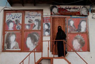 Женщина в никабе заходит в салон красоты. Кабул, 6 октября 2021 года