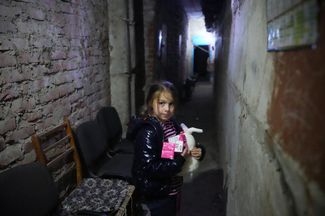 Девочка позирует в подвале своего дома, где она со своей матерью проводит практически все время из-за постоянных боев рядом с городом