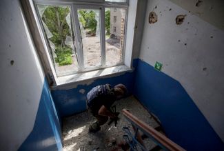 Украинский полицейский в школе города Марьинка Донецкой области. Его задача — проверить, нет ли в здании школы местных жителей, которых нужно эвакуировать в безопасное место