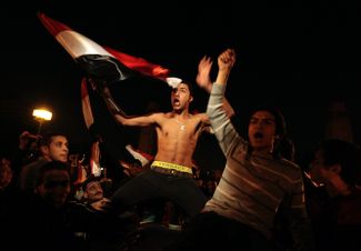 11 февраля 2011 года. Протестующие празднуют отставку Мубарака в Каире. Он объявил об уходе от власти меньше чем через месяц после начала протеста