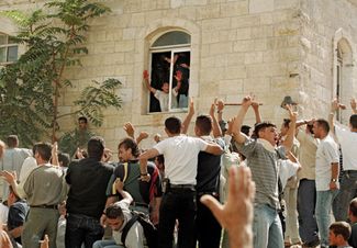 Палестинец показывает кровь израильтянина на своих руках. Его приветствуют другие протестующие. Рамаллах, 12 октября 2000 года. 
