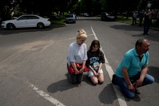 Жители Фастова на коленях во время прощания с Андреем Коняевым