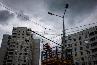 Коммунальщик восстанавливает линии электропередач, поврежденные обстрелом в харьковском районе Салтовка.