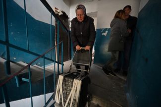 Жительница Чернигова забирает свои уцелевшие вещи из обстрелянного жилого дома
