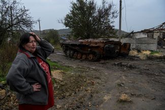 Жительница Каменки рядом с уничтоженной военной техникой
