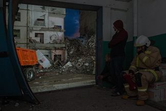 Спасатели и волонтеры, разбирающие завалы разрушенного дома, прячутся во время воздушной тревоги. 12 мая 2024 года