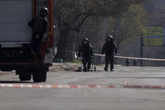 Украинские саперы обезвреживают неразорвавшиеся снаряды на улицах Харькова.