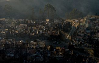 Дым от лесного пожар и сгоревшие дома в пригороде Винья-дель-Мар. К этому городу, где живут около 330 тысяч человек, огонь подошел вплотную. 3 февраля 2024 года