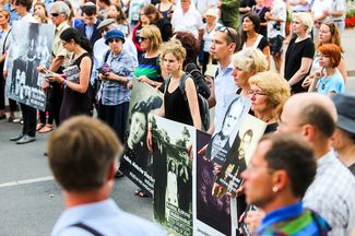 Участники марша памяти жертв холокоста в Молетае держат портреты литовцев, которые спасали евреев, и евреев, которых спасли литовцы