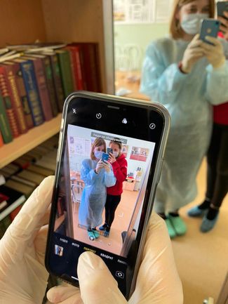 Blood donations coordinator Lyubov poses for a photo with a regular donor in the early days of the quarantine. Because of their masks, her iPhone fails to recognize that people are present in the shot.