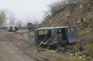 Тела убитых армянских солдат на дороге к Шуше, на заднем плане — грузовик российских миротворцев. 13 ноября 2020 года
