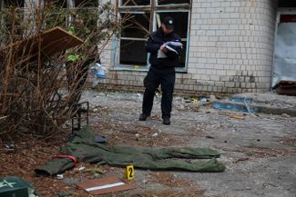 Эксперт-криминалист украинской полиции осматривает предметы, оставшитеся после российской оккупации села Бервица к северо-востоку от Киева