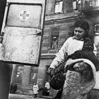 Санитары эвакуируют жертв немецкого артобстрела во время блокады Ленинграда. Осень 1941 года