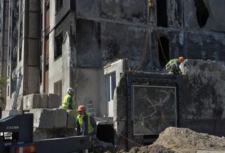 Рабочие готовятся демонтировать часть стены с граффити Бэнкси в Ирпене
