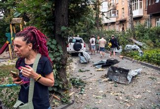 Жители Киева возле своего дома, поврежденного во время российского ракетного удара