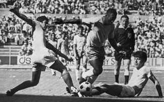 Пеле обыгрывает защитников румынской сборной перед тем, как открыть счет в матче группового этапа ЧМ-1970 на стадионе «Халиско» в Гвадалахаре 10 июня 1970 года. Бразилия выиграла у Румынии со счетом 3:2 и вышла в плей-офф, победив во всех матчах группы (4:1 против Чехословакии и 1:0 против Англии).