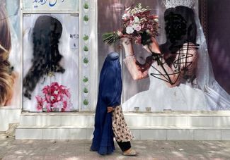 Закрашенные женские лица на рекламных плакатах в Кабуле. 20 августа 2021 года
