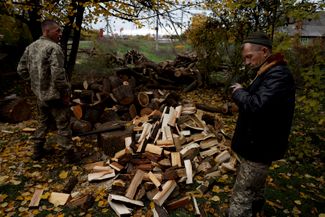 Украинские военнослужащие колют дрова для обогрева и приготовления пищи в селе близ линии фронта в Донецкой области