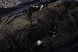 Украинские СМИ сообщают об идентификации погибших российских солдат, которая проходит под Харьковом. Среди них — этот солдат с тремя парами часов на руке.