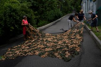 Прихожане церкви в Киеве готовят камуфляжную сеть к отправке на передовую