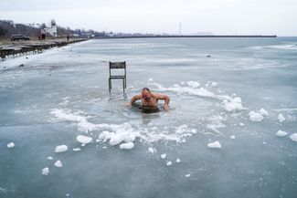 Мужчина во время крещенских купаний на берегу Таганрогского залива в Мариуполе. Температура — плюс 5 градусов