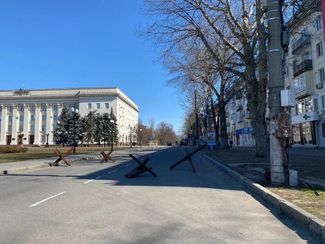 Противотанковые ежи на площади Свободы. За ними — здание облсовета, занятое российскими военными