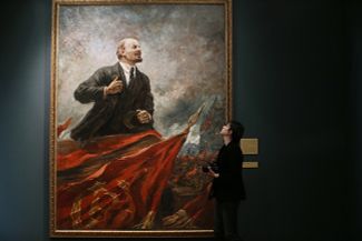 Посетитель выставки картин Александра Герасимова в Историческом музее на фоне работы «Ленин на трибуне».