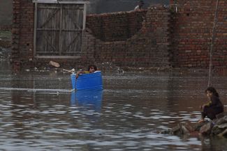 Житель города Джейкобабад плывет по нему в пластиковой бочке<br><br>
