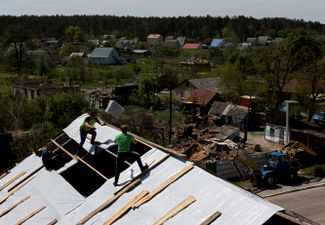Мужчины чинят крышу в селе Мощун
