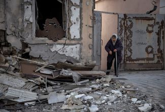 Пожилая жительница Херсона возле своего дома, уничтоженного российским ударом