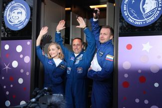 Юлия Пересильд, Клим Шипенко и Антон Шкаплеров приветствуют собравшихся у входа на космодром Байконур. 5 октября 2021 года