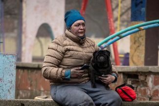 Жительница Голосеевского района Киева со своей собакой после ракетного удара