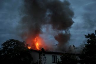 Украинские пожарные тушат огонь в жилом доме, возникший после удара войск РФ по Харькову