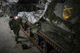 Украинский военный рядом с разбитой самоходной гаубицей