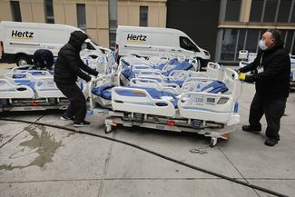 Сотрудники госпиталя в Нью-Йорке готовят новые кровати для пациентов. 31 марта 2020 года