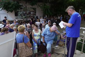 Жители Мелитополя в очереди за гуманитарной помощью, которую выдают пророссийские власти города. 2 августа 2022 года