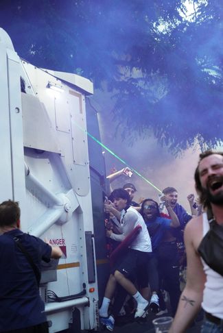 Fans in Paris try to climb into the garbage truck