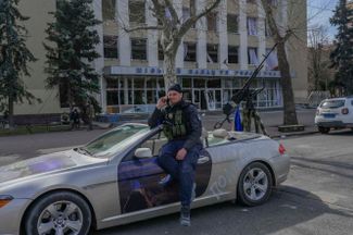 Украинский полицейский у спортивной машины, оборудованной крупнокалиберным пулеметом. Николаев