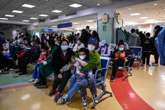 Дети и их родители в амбулаторном отделении детской больницы в Пекине. 24 ноября 2023 года