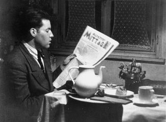 Соломон Перель читает газету в своей комнате в Мюнхене — накануне отъезда в Палестину. Март 1947 года